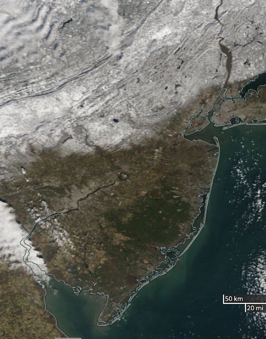 Figure 5. NASA MODIS visible satellite image on the morning of January 8th showing snow cover over New Jersey and surroundings north of approximately Route 1. The dark spot in west central NJ is unfrozen Round Valley Reservoir (Hunterdon). NJ skies are mostly cloud-free with some clouds lying in the southwest and others to the northwest over Pennsylvania’s Poconos. NASA MODIS visible satellite image on the morning of January 8th showing snow cover over New Jersey and surroundings north of approximately Route 1.