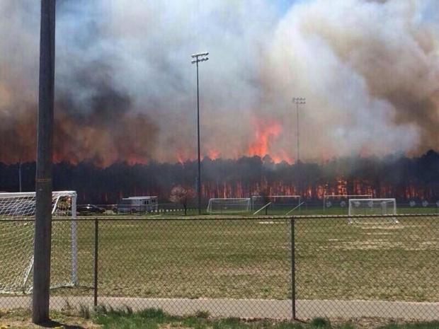 A wildfire rages behind a school soccer field in Beachwood On April 24, 2014. Photo by @PhitinsPhan via Twitter. Wildfire photo