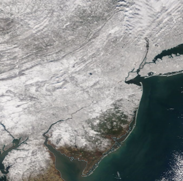 Figure 5. NASA MODIS visible satellite image on the morning of February 4th showing all but extreme southern and portions of south coastal NJ snow covered. The dark spot in west central NJ is unfrozen Round Valley Reservoir (Hunterdon). NJ skies are cloud free with some clouds lying just north of the NJ border. Satellite image of snow cover on the morning of February 4th